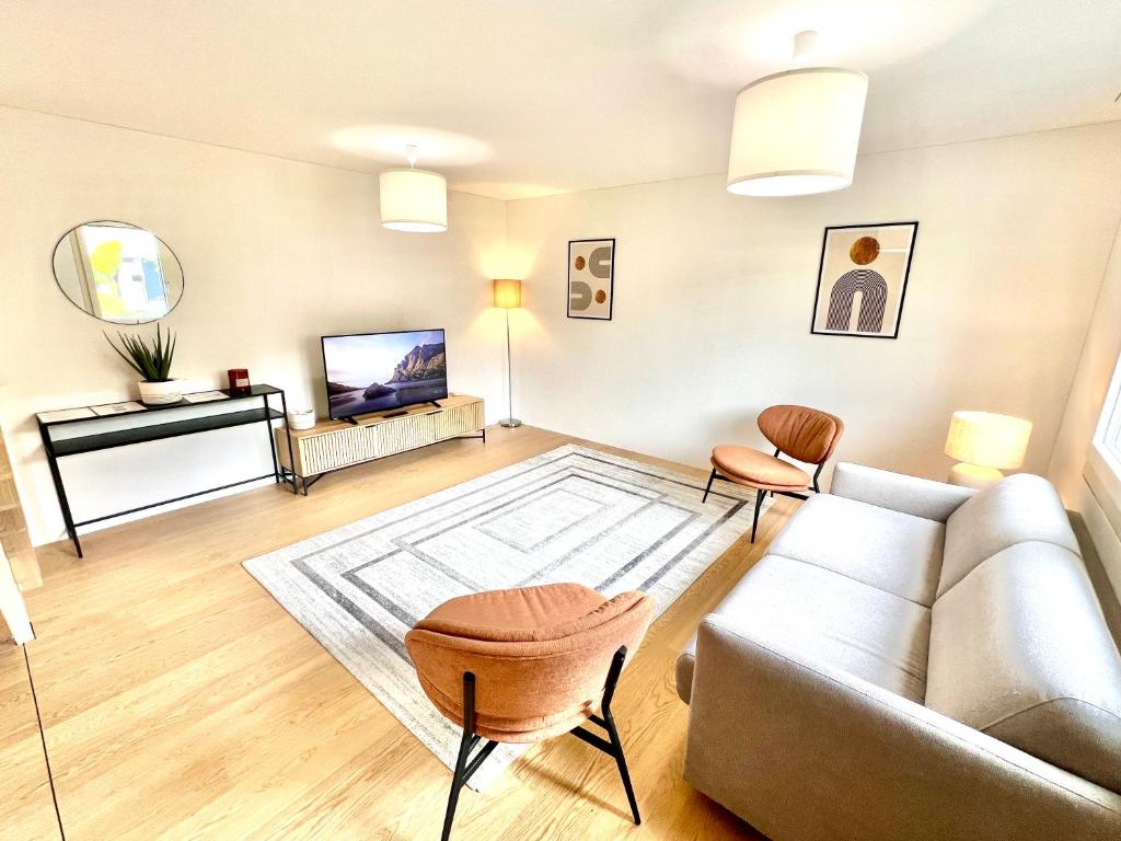 Una sala de estar con un sofá y un televisor. en WA - Luxury House - Zug - 8 Pax, en Arni Alp