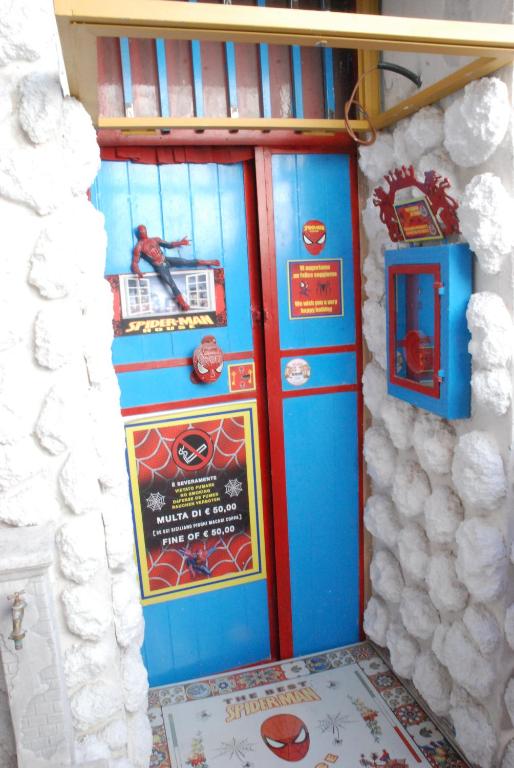 a blue door with a poster on the side of a building at Catania SpidermanHouse I in CTA