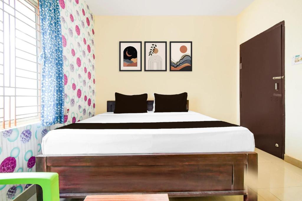 a bedroom with a bed and pictures on the wall at Hotel O Unicorn Guest House in Jānla