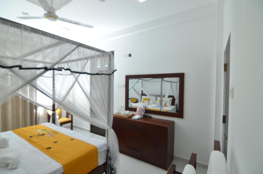 a bedroom with a canopy bed and a mirror at BeeYu River Lodge Weligama in Weligama