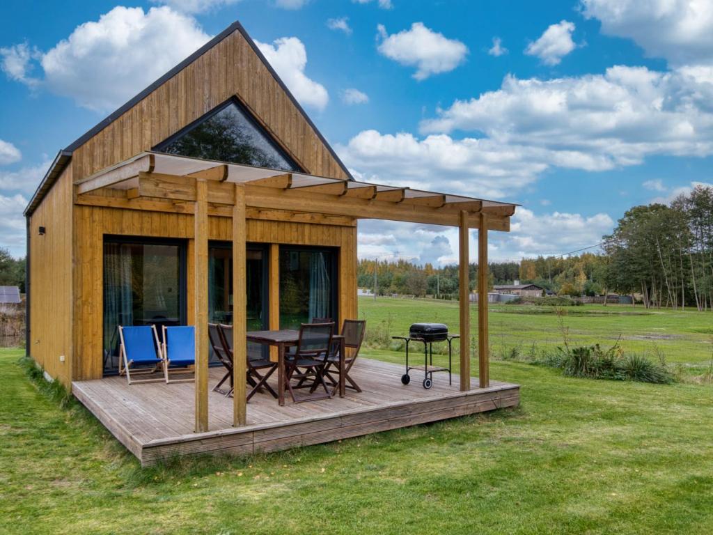 a cabin with a table and chairs on a deck at Dom nad Stawem in Wielgie
