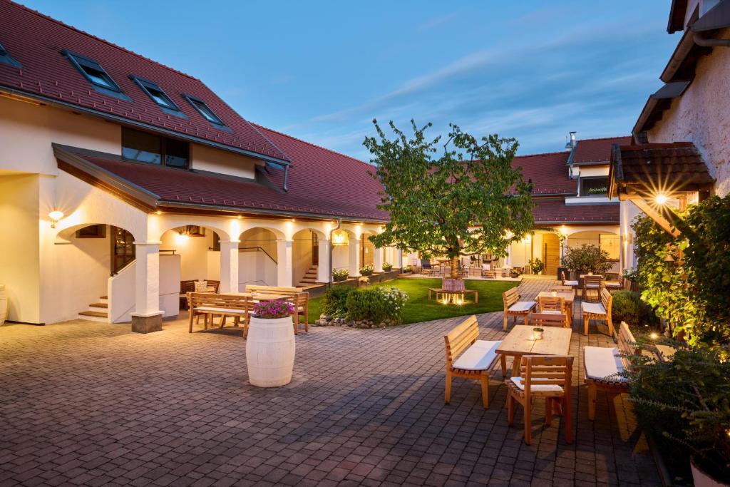 an outdoor patio with tables and chairs in a courtyard at Winzerhof Kiss in Jois