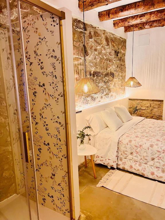 a bedroom with a bed and a stone wall at ruralhomemora in Mora de Rubielos