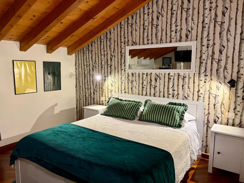 a bedroom with a bed with green pillows at B&B La Borasca - Rooms in Casalpusterlengo