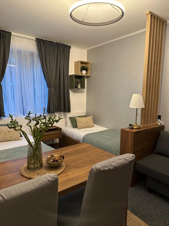 a hotel room with two beds and a table and chairs at Riverside Apartmani Kopaonik in Brzeće