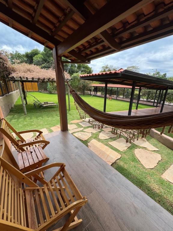 a hammock on a porch with a park in the background at Pousada Camarás in Alto Paraíso de Goiás