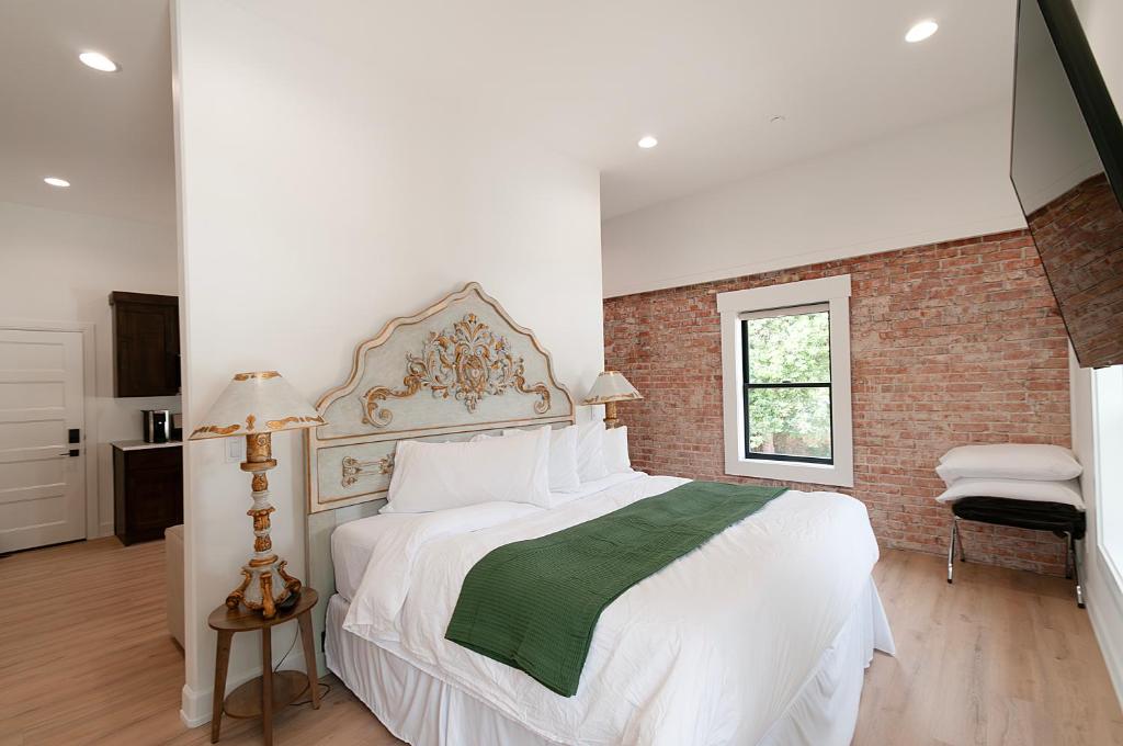 a bedroom with a large white bed and a brick wall at The Suites of Lava Hot Springs in Lava Hot Springs