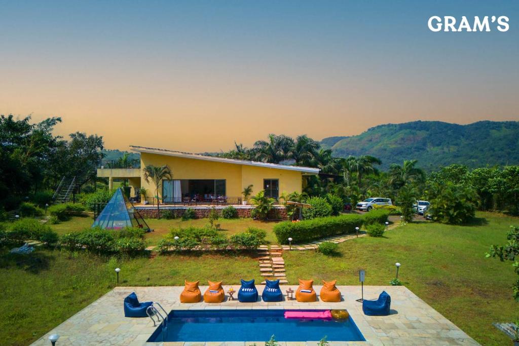 a house with a yard with a swimming pool at Gram's at Shivom, Pawna Lake in Lonavala