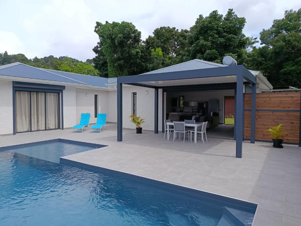 a house with a swimming pool and a patio at Villa 4 étoiles Bon Air in Bouillante
