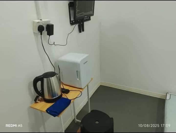 a room with a desk with a computer and a tv at D-Bayu Motel in Papar