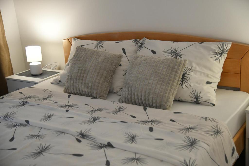 a bed with black and white sheets and pillows at Apartman Dimić, Vrnjačka Banja in Vrnjačka Banja