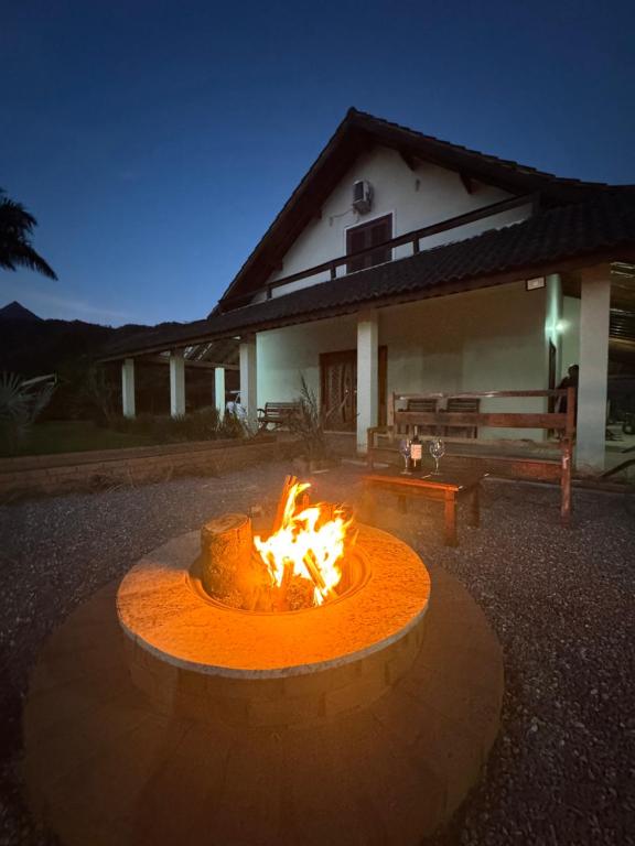 a fire pit in front of a house at night at Recanto Vale Minã in Lavrinhas