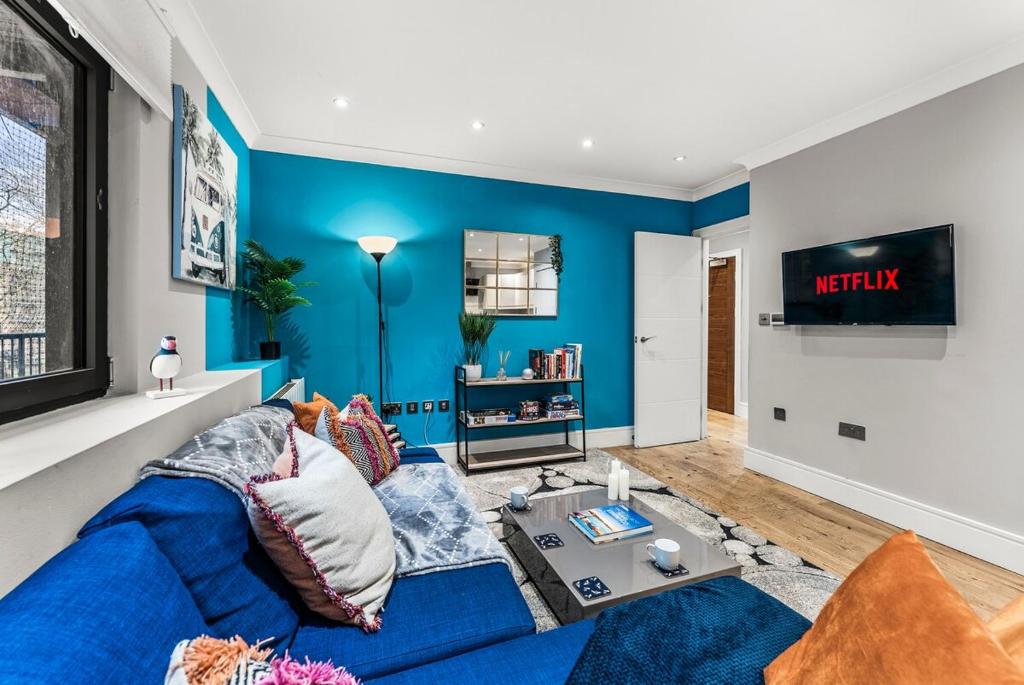 a living room with blue walls and a blue couch at Beautiful 2 Bedroom Home In Bristol in Bristol