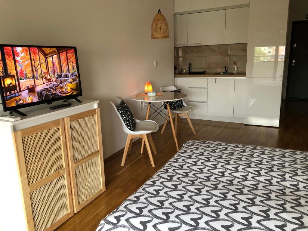 a living room with a television and a table with chairs at Tesla 30 in Kruševac