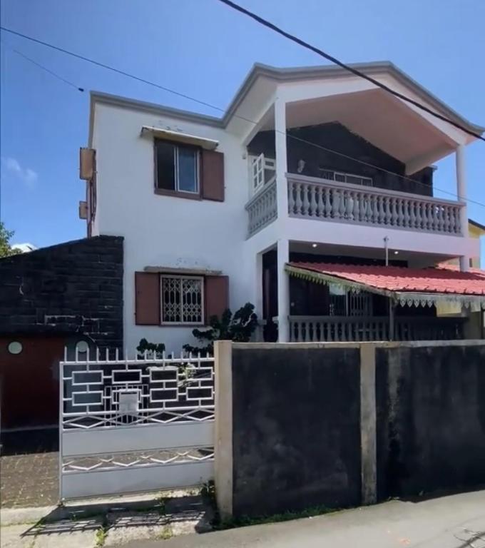 a house with a fence in front of it at FINRAH Rental Property Ltd in Curepipe