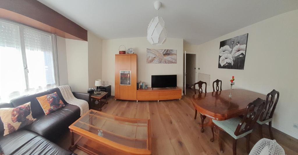 ein Wohnzimmer mit Sofa und Tisch in der Unterkunft Apartamentos Maliayo A in Villaviciosa