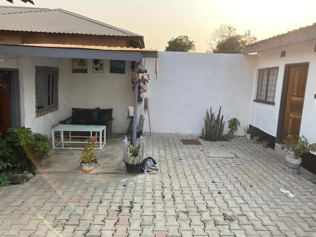 a patio in front of a white house at Che-Joy Budget Lodge in Kitwe