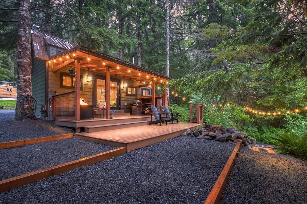 a small log cabin in the woods with lights at L'il Finch at Mount Rainier in Ashford