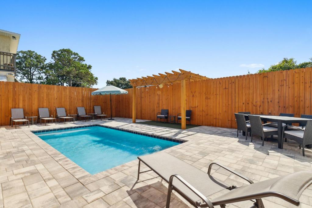 a swimming pool with chairs and a table and a fence at Grand Retreat II: 4BR, 5BA, sleeps 15 Private pool Your perfect escape! in Sunnyside