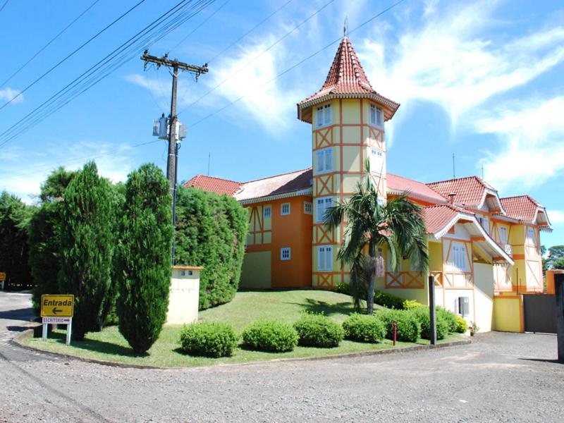 a building with a tower on the side of it at Exos Castelinho Motel in Concordia