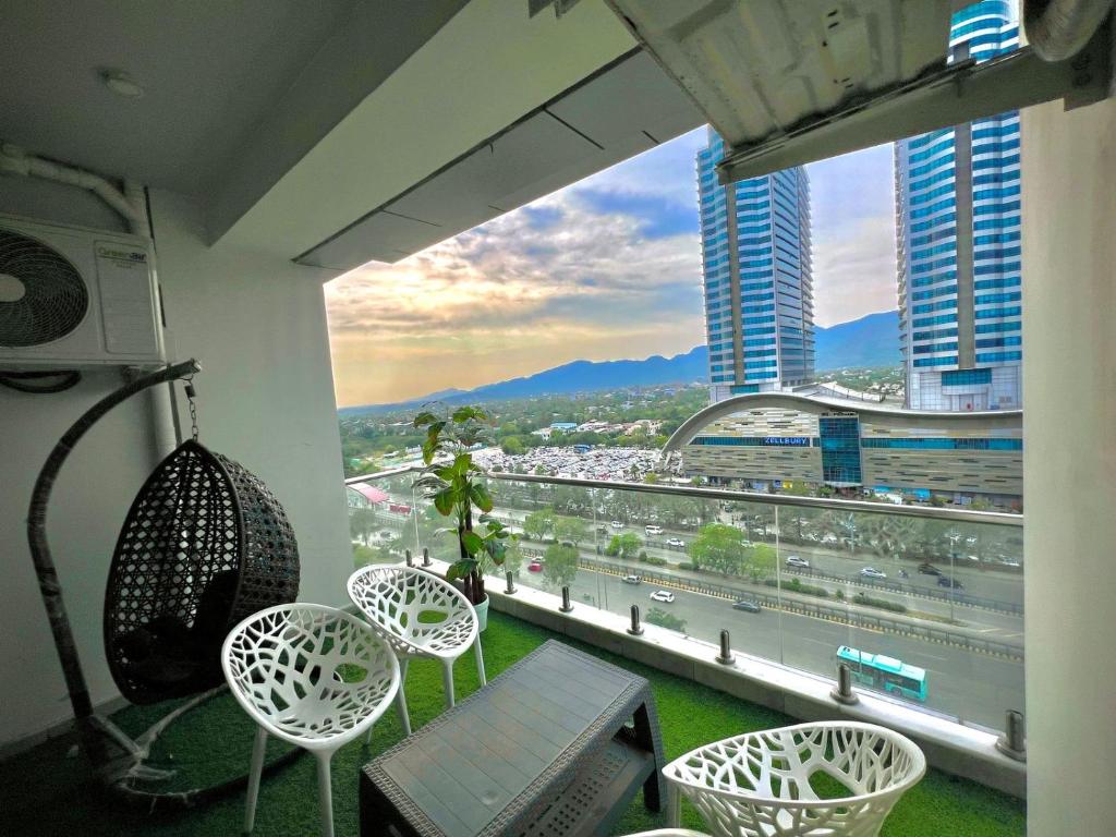 a balcony with chairs and a view of a city at Elysium Grand Heights Facing Iconic Centaurus Mall Islamabad in Islamabad