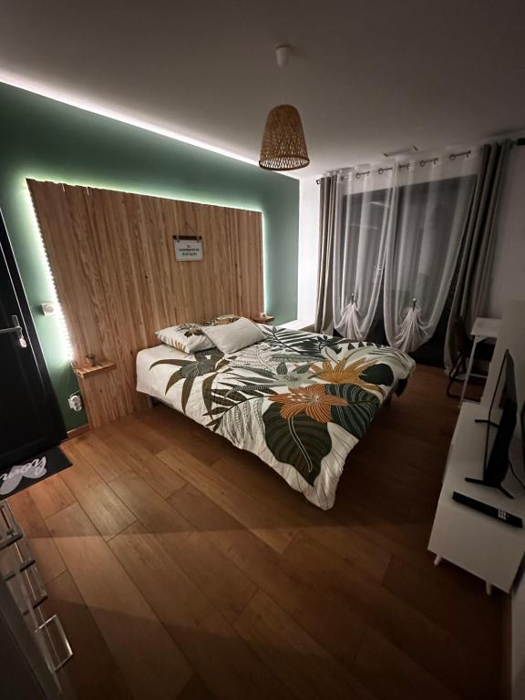 a bedroom with a bed and a green wall at Chambres modernes avec salle de bain privative in Saint-Pierre-du-Mont