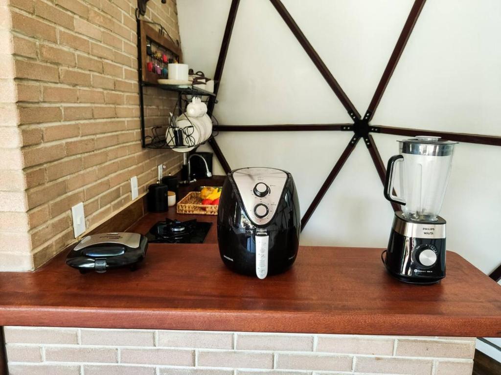 a counter with a blender on a brick wall at Domo na praia - Arraial D'Ajuda in Arraial d'Ajuda