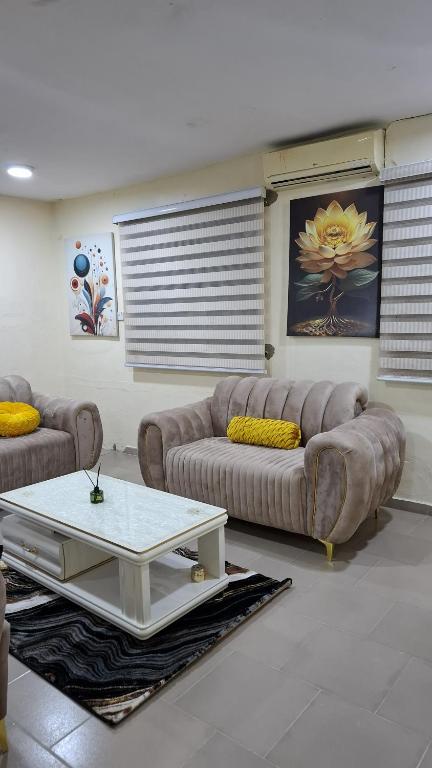 a living room with two couches and a coffee table at Rennyshouse 3 Bedroom Apartments in Alimosho