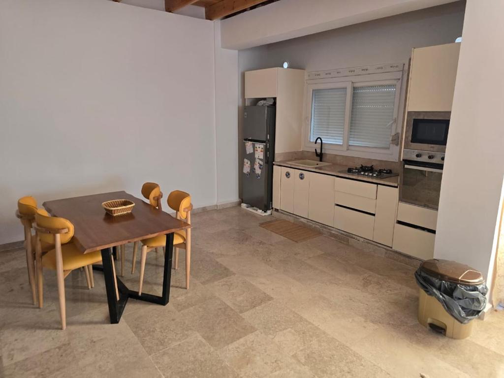 a kitchen with a table and chairs and a refrigerator at Sarl piscine chaufente familial in Alger