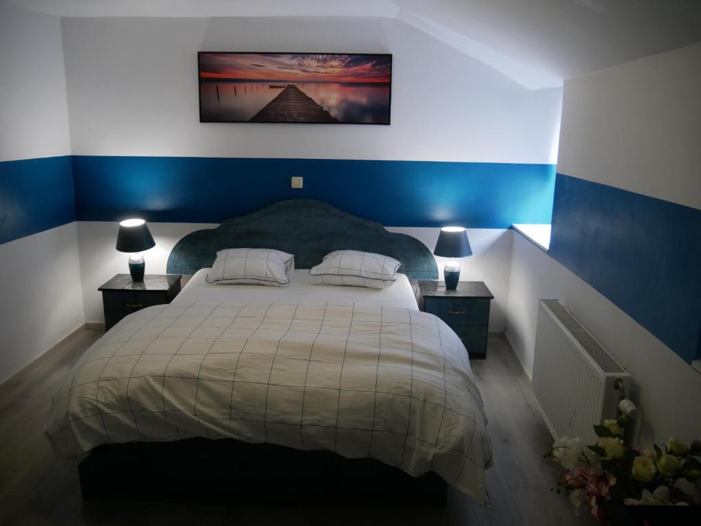 a bedroom with a large bed with blue walls at VancyLove Home in Mons
