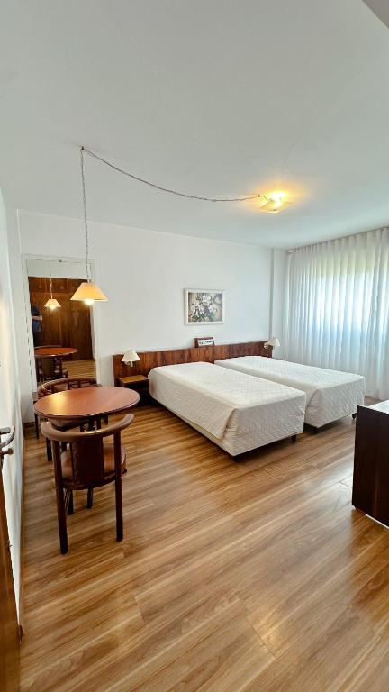 a hotel room with two beds and a table at Canoas Parque Hotel in Canoas