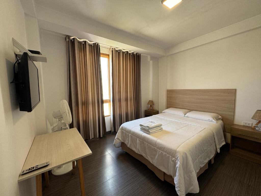 a hotel room with a bed and a television at Betania in Paracas