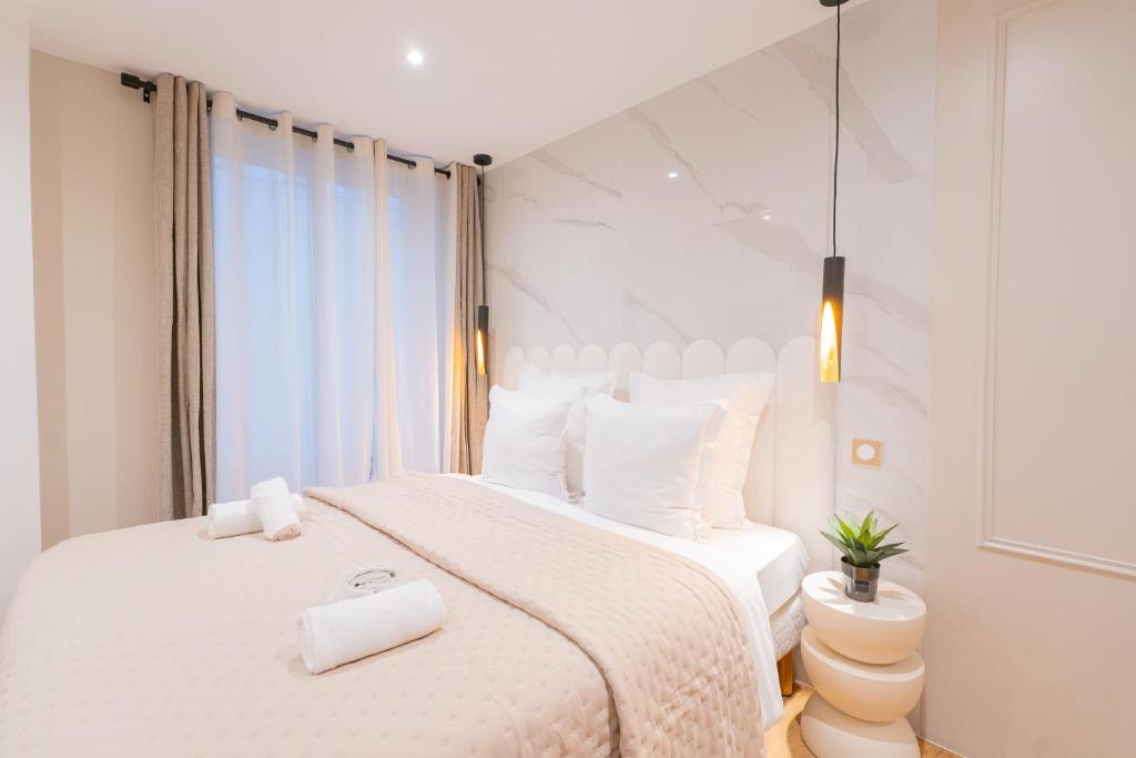 a white bedroom with a large bed with white sheets at Luxurious Apartment Stylish Design - René Boulanger in Paris
