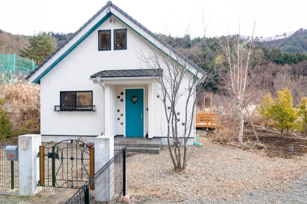ein kleines weißes Haus mit blauer Tür in der Unterkunft TOCORO, MT,FUJI Mutsuki - Vacation STAY 03957v in Funatsu