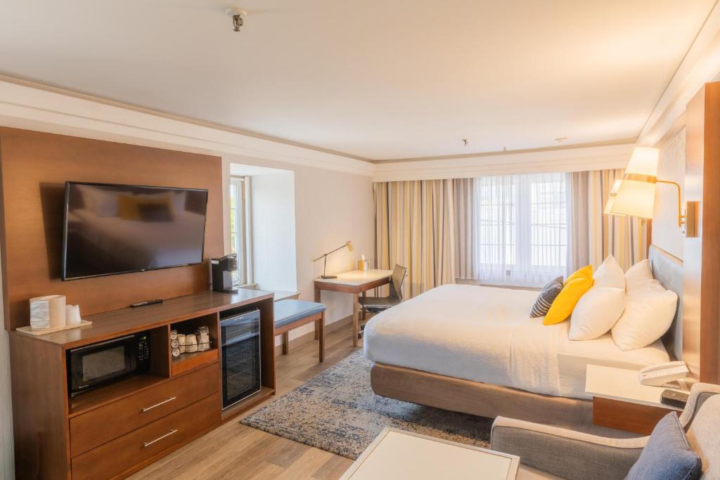 a hotel room with a bed and a flat screen tv at The Westfield Inn, BW Signature Collection in Westfield