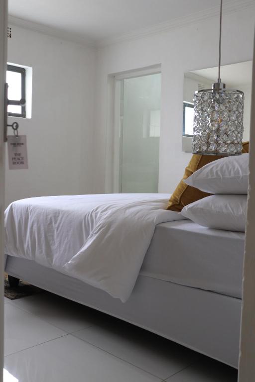 a white bed with white sheets and pillows at The Hide Nongoma in Nongoma