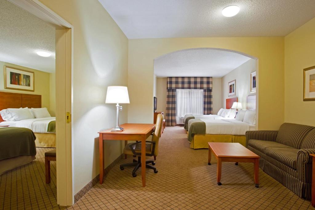 a hotel room with two beds and a couch at Holiday Inn Express Hotel & Suites Goshen by IHG in Goshen