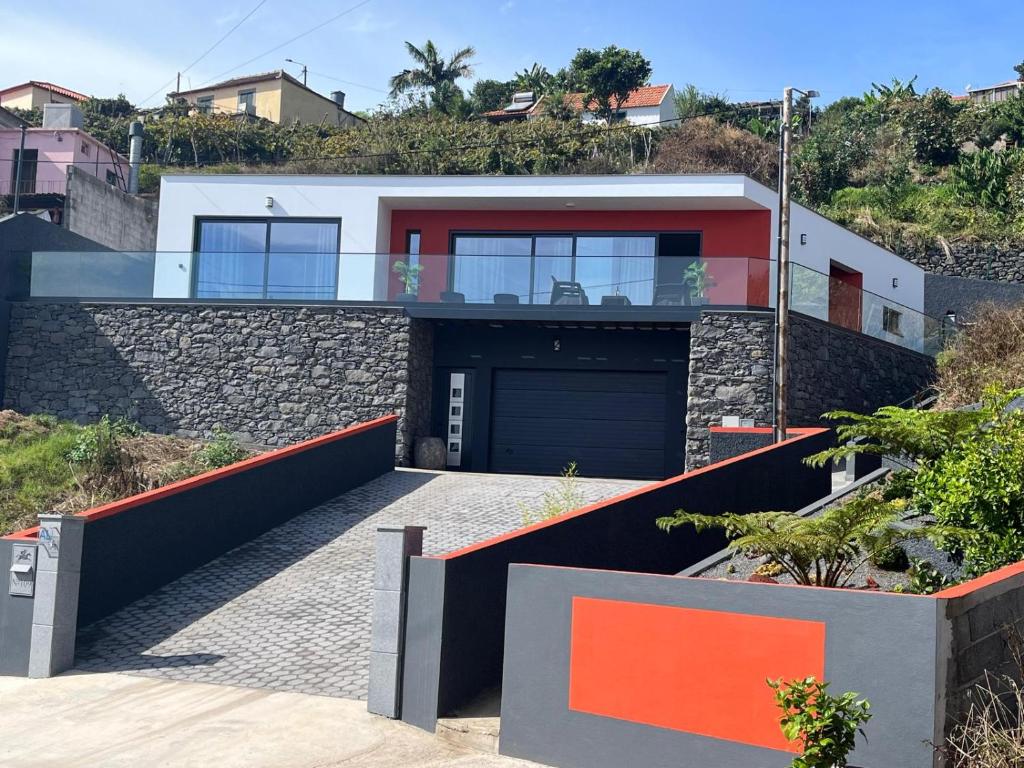 a house on a hill with a garage at Villa Bacana Oasis in Estreito da Calheta