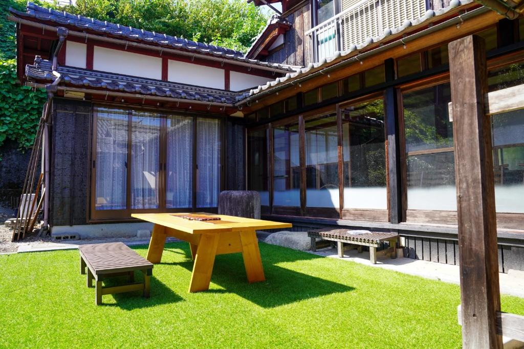 ein Picknicktisch und eine Bank in einem Hof in der Unterkunft LYS AIBA House - Japanese Garden Villa - Vacation STAY 79096v in Aiba