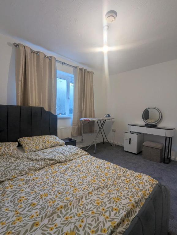 a bedroom with a bed and a desk and a window at 3SIEE Homes in Luton