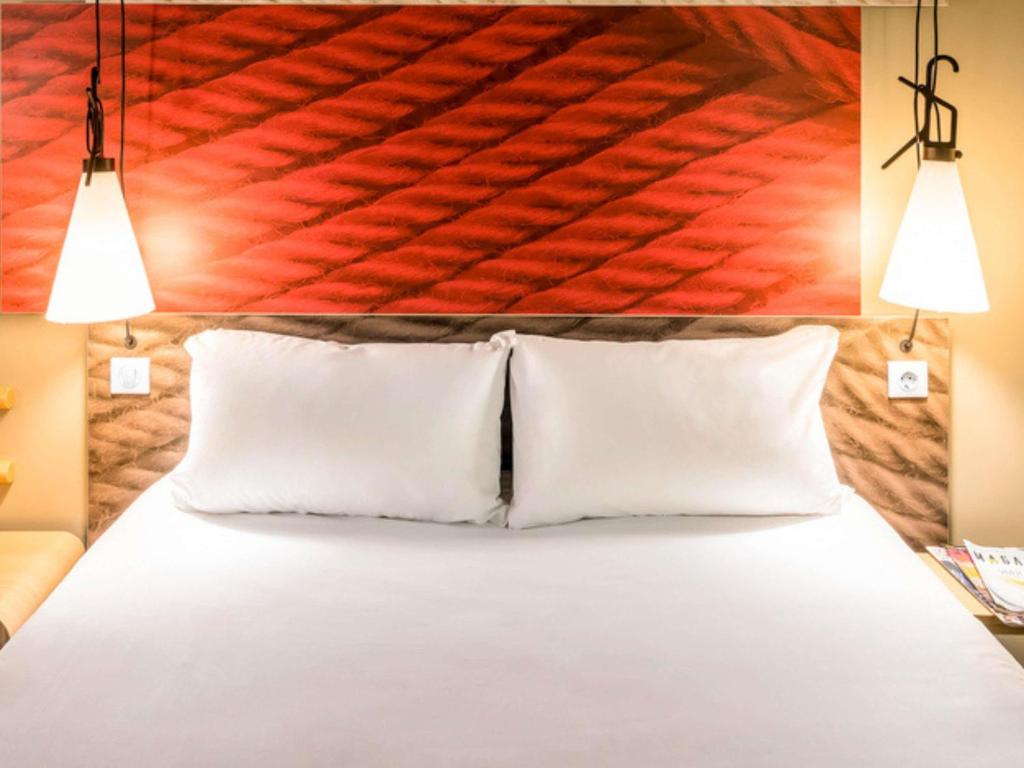 a bedroom with a bed with two pillows at ibis Santos Gonzaga Praia in Santos