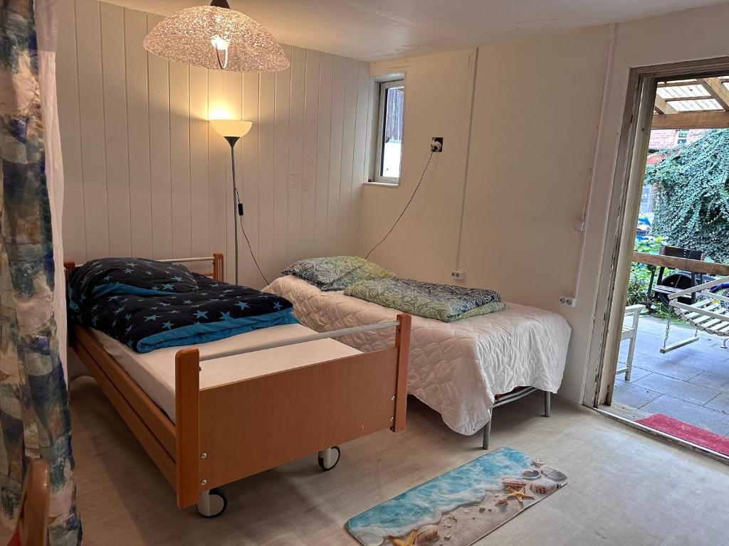 BrakelにあるBrakel Monteu - Fererien Wohnung 2 Zimmerのベッドルーム1室(ベッド2台、ランプ、窓付)