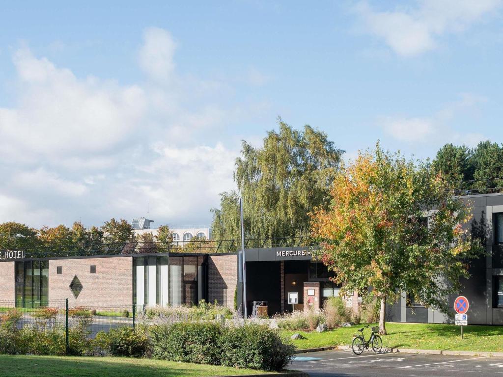 un bâtiment avec un vélo garé devant lui dans l'établissement Mercure Caen Cote De Nacre, à Caen