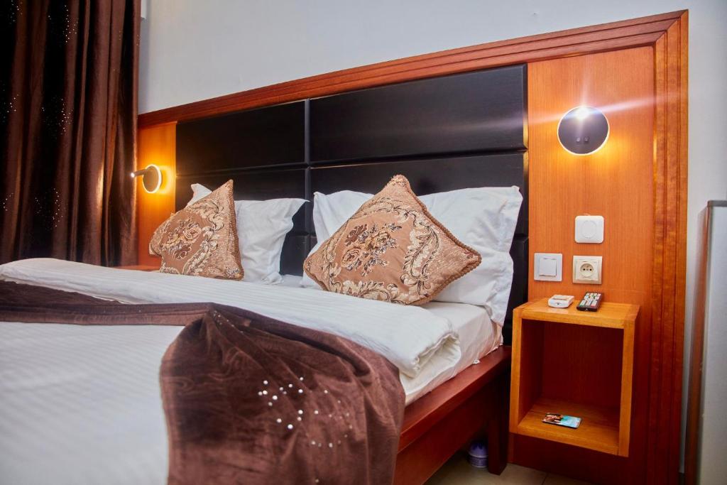 a bedroom with a large bed with pillows on it at Residence samba in Douala
