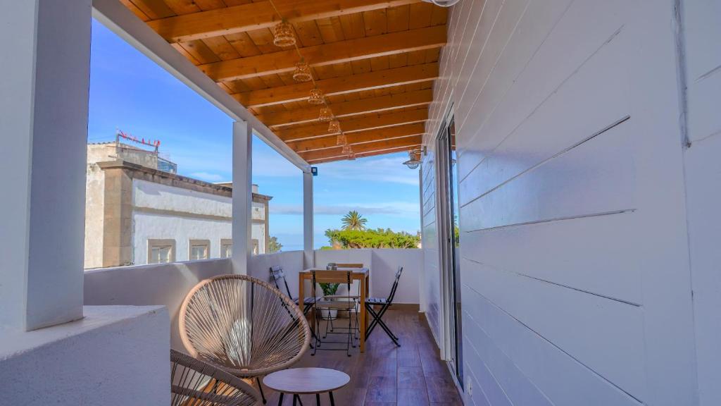 a balcony with chairs and a table on a building at Casa Yeye City Loft in Agaete