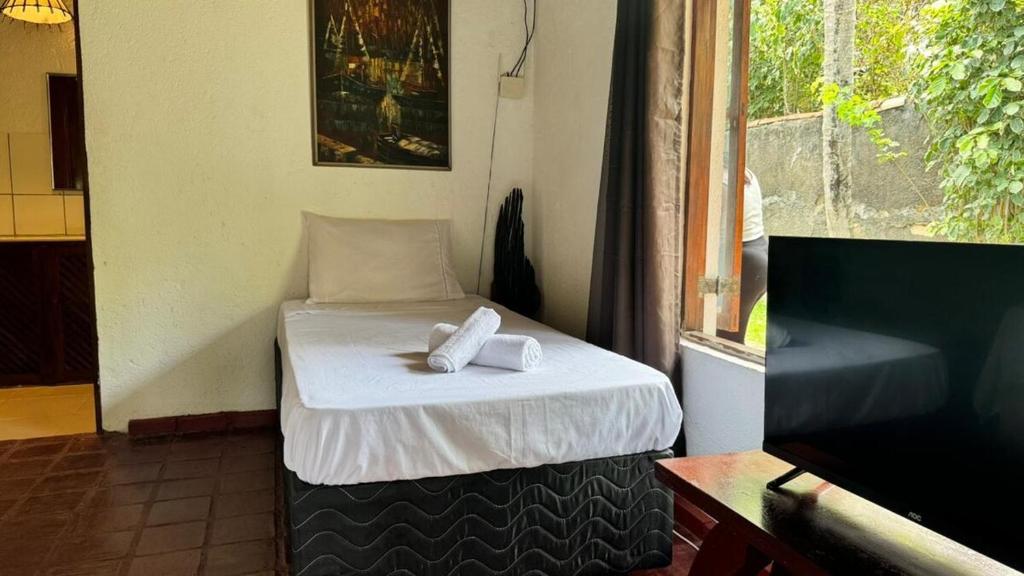 a small bed with two towels on it in a room at Ibiza in Arraial d'Ajuda