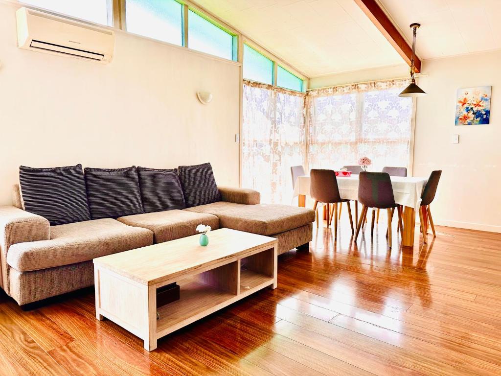 una sala de estar con un sofá y una mesa en Beautiful villa by the sea, en Auckland