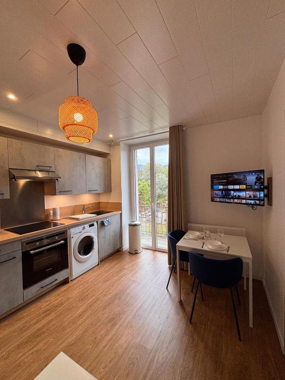 a kitchen with a table and a dining room at Le Nébula - rénové - parking - proche centre ville in La Roche-sur-Foron