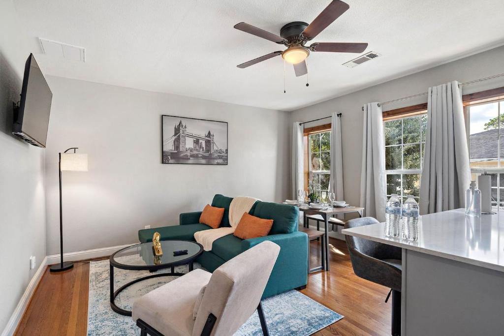a living room with a blue couch and a ceiling fan at Homey Apt Nr Med Center Fire Pit Bbq Wifi Games in Houston