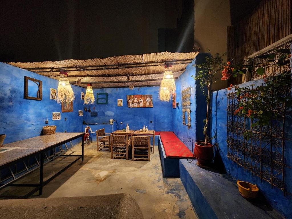 a room with blue walls and a table and benches at Charming Moroccan Guest House with Patio & Terrace in Fès